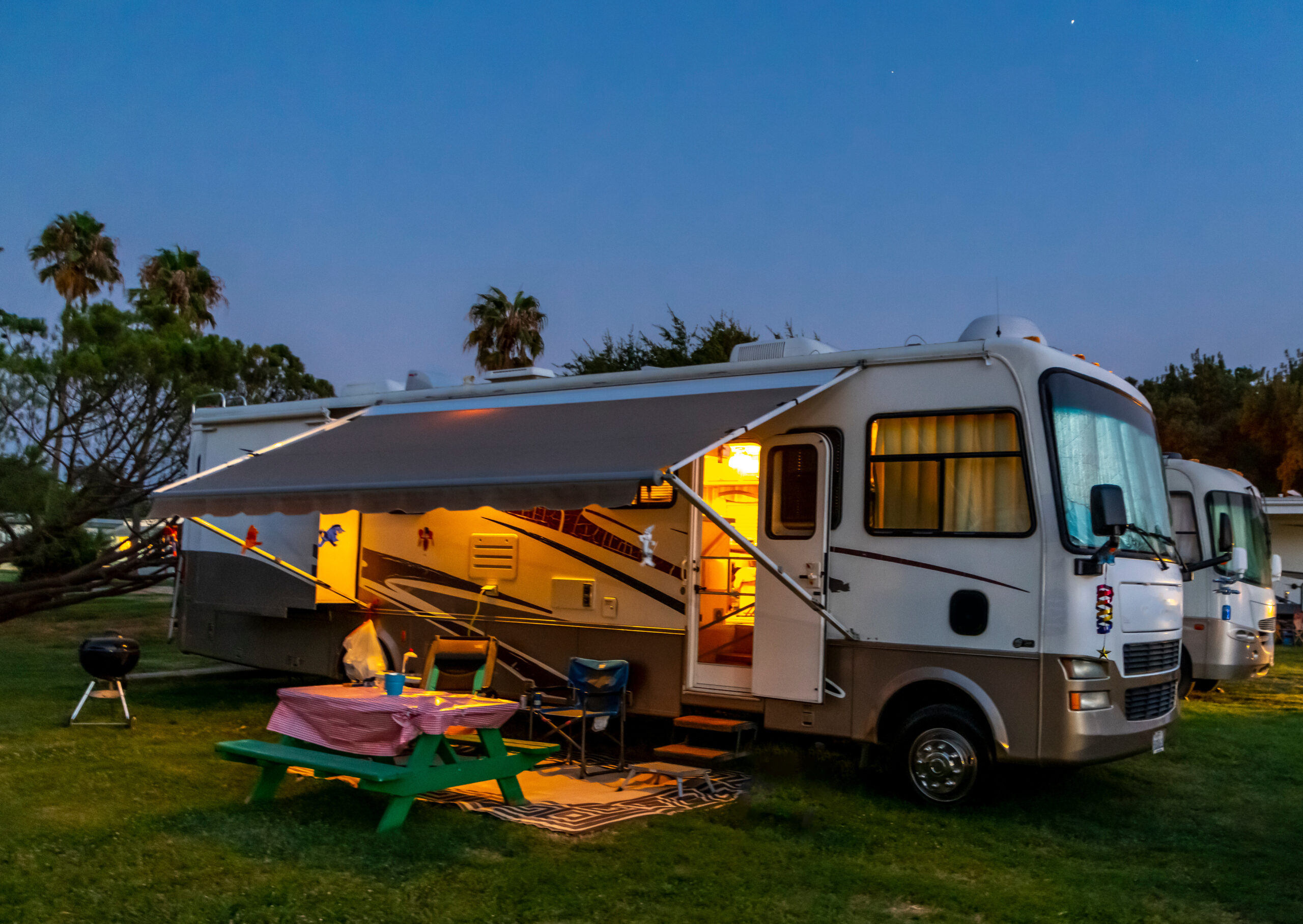 Rv camping in a Rv resort under the evening sky with lights on the coach