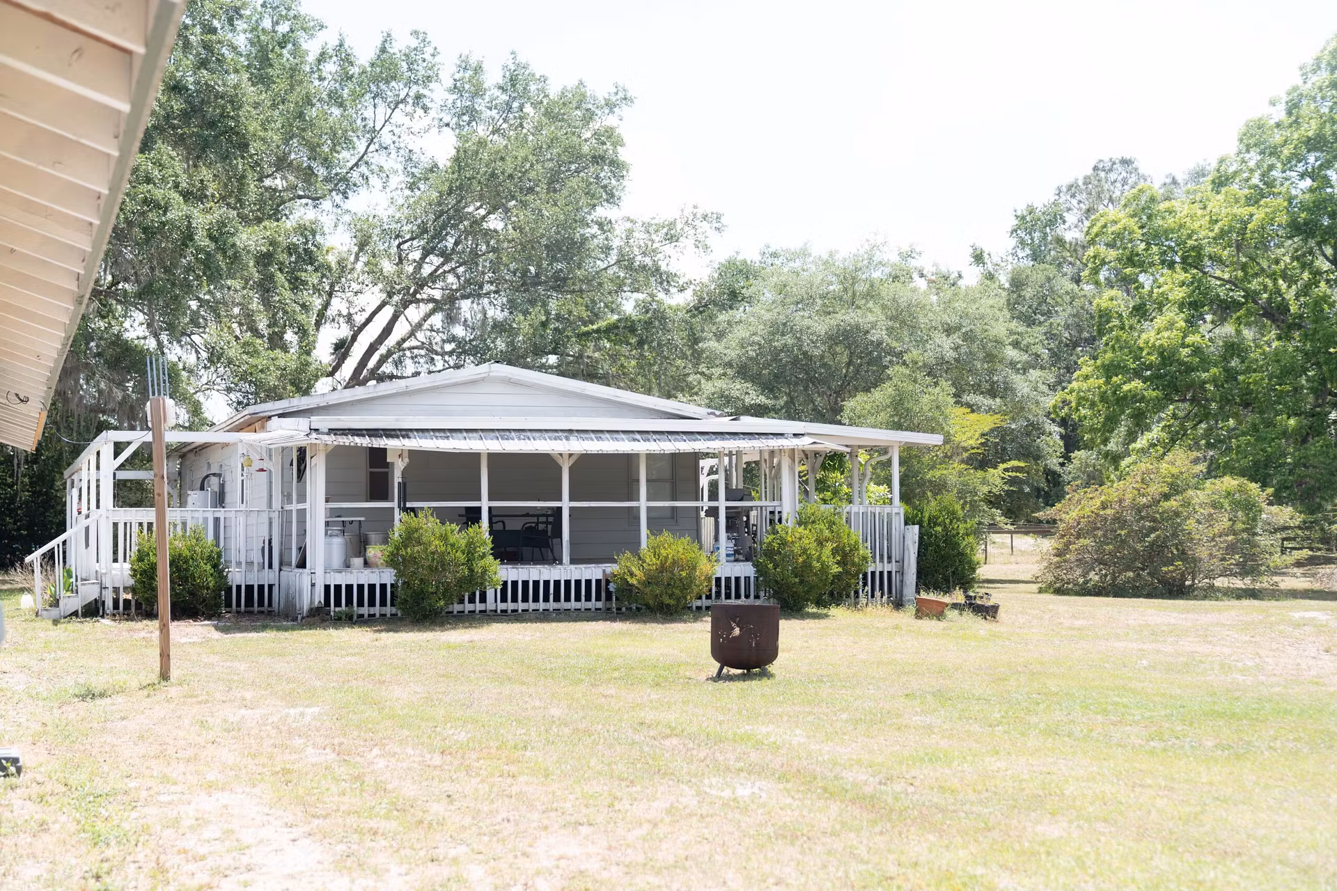home or mobile home with large white covered porch