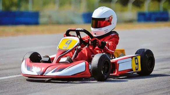 person enjoying racing on four wheeled go kart