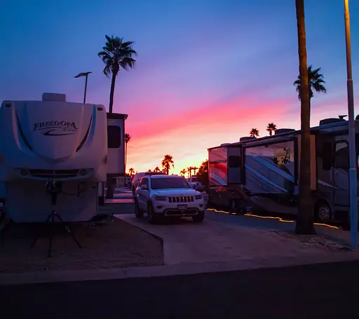 RV parked on a road during sunset