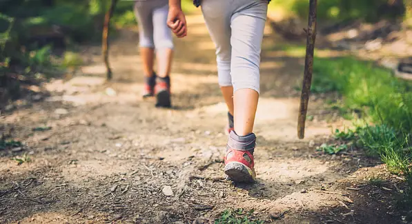two persons walking together on path
