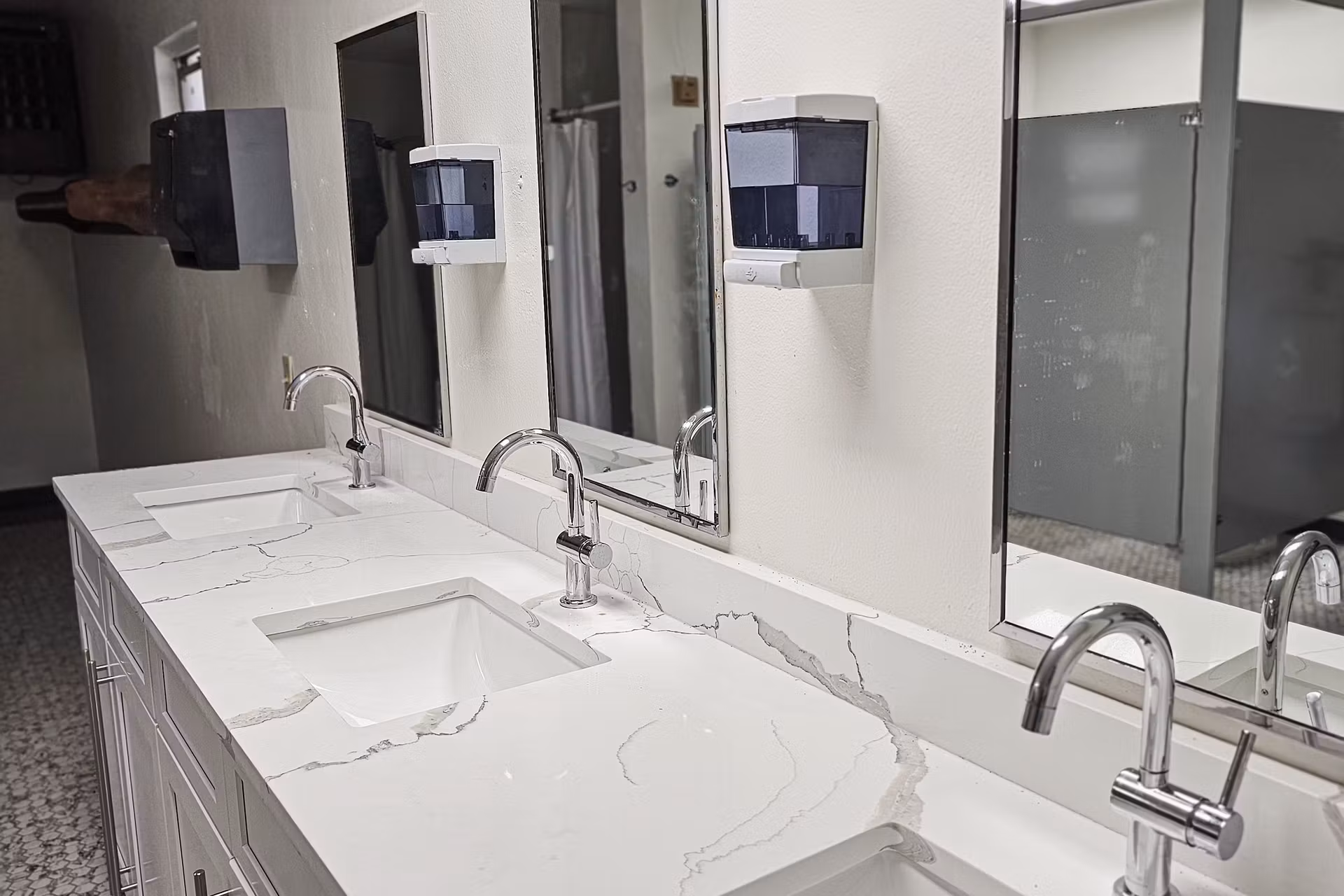 white bathrooms with three vanity and sinks